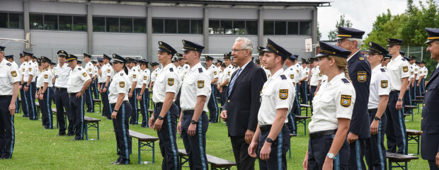 Innenminister Herrmann zwischen neu vereidigten Polizistinnen und Polizisten